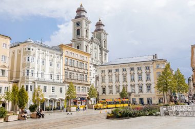 Linz, Avusturya, 27 Ağustos 2021: Barok Eski Katedrali veya iki kulesi olan Alter Dom, Ignatius Kilisesi, Hauptplatz veya güneşli yaz günü ana meydanı, taş renkli tarihi binalar cephesi