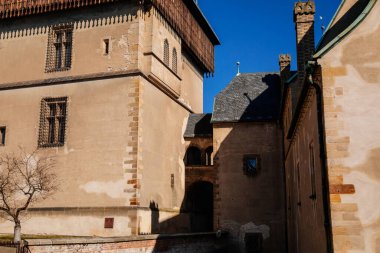 Karlstejn, Bohemya, Çek Cumhuriyeti, 12 Mart 2022: Kral 4. Charles tarafından kurulan eski bir ortaçağ Gotik kalesi, güneşli bahar gününde mavi gökyüzü, ünlü bir dönüm noktası, güçlendirilmiş surlar.