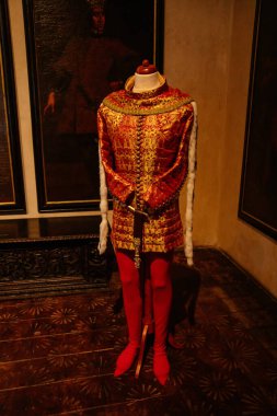 Karlstejn, Çek Cumhuriyeti, 12 Mart 2022: Ortaçağ Gotik kalesi iç mimarisi, antik ahşap oyma mobilyalar, altın işlemeli kırmızı kraliyet bornozu örnekleri, duvarlarında kralların portreleri olan büyük salon