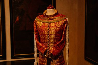 Karlstejn, Çek Cumhuriyeti, 12 Mart 2022: Ortaçağ Gotik kalesi iç mimarisi, antik ahşap oyma mobilyalar, altın işlemeli kırmızı kraliyet bornozu örnekleri, duvarlarında kralların portreleri olan büyük salon