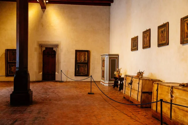 Karlstejn, Çek Cumhuriyeti, 12 Mart 2022: Ortaçağ Gotik kalesi iç mimarisi, antik ahşap oyma mobilyalar, antik ahşap sandık, duvarlarında ikonlar olan büyük salon, klasik kapı.