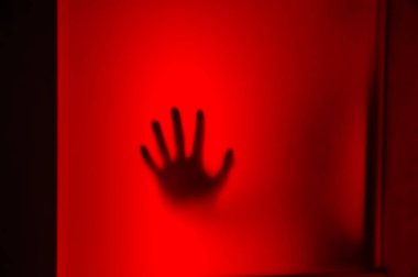 Donmuş camın, şiddetin, korkunun, cadılar bayramının kapana kısılmış halinin ve panik konseptinin, yüzsüz kişinin, soyut bulanık ellerin, bulanık ve yumuşak odak noktasının, kırmızı, turuncu ve siyah