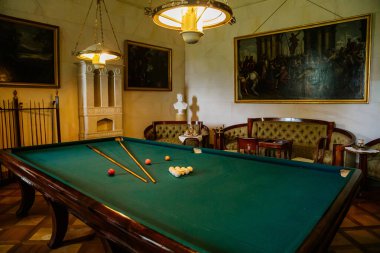 Lazne Kynzvart, Çek Cumhuriyeti, 7 Ağustos 2021: Metternich temsili şato veya kale iç mimarisi, ahşap barok ve bilardo masalı klasik mobilya, beyaz seramik kaplama ocak