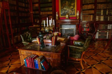 Lazne Kynzvart, Çek Cumhuriyeti, 7 Ağustos 2021: Metternich temsili şato veya kale içi, barok ve klasik mobilyalı kütüphane, ahşap oyma masa ve kitaplıklar, yumuşak koltuklar