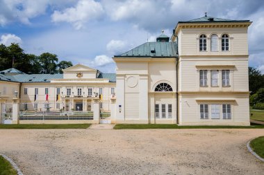 Lazne Kynzvart, Batı Bohemya, Çek Cumhuriyeti, 7 Ağustos 2021: Sarı ve Beyaz Temsilci Şatosu veya Viyana Klasikçiliği tarzında yaz kalesi, yeşil çimenler, güneşli bir günde avluda çeşme