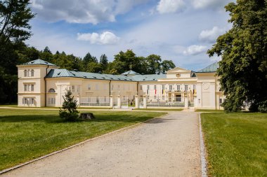 Lazne Kynzvart, Batı Bohemya, Çek Cumhuriyeti, 7 Ağustos 2021: Sarı ve Beyaz Temsilci Şatosu veya Viyana Klasikçiliği tarzında yaz kalesi, yeşil çimenler, güneşli bir günde avluda çeşme