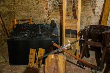 Cheb, Western Bohemia, Czech Republic, 14 August 2021: Gothic stone castle, medieval historic fortress or stronghold, torture room, executioner's sword and axe, guillotine in old medieval chamber 