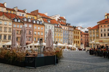 Varşova, Polonya, 13 Ekim 2021: Eski kentte fıskiyeli ana pazar meydanı, güneşli bir günde ortaçağ renkli tarihi Rönesans barok binaları, UNESCO Dünya Mirası Sitesi, antik mimari