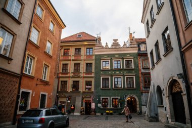 Varşova, Polonya, 13 Ekim 2021: Ortaçağ şehri, Rönesans ve barok tarihi binalarının tarihi merkezlerinde renkli binalar bulunan dar resimli cadde, eski kentte güneşli bir sonbahar günü