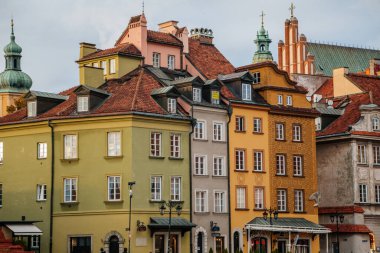 Varşova, Polonya, 13 Ekim 2021: Ortaçağ şehri, Rönesans ve barok tarihi binaların tarihi merkezlerinde güneşli bir gün olan Castle Meydanı 'ndaki renkli binalar