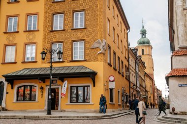 Varşova, Polonya, 13 Ekim 2021: Ortaçağ şehri, Rönesans ve barok tarihi binalarının tarihi merkezlerinde renkli binalar bulunan dar resimli cadde, eski kentte güneşli bir sonbahar günü