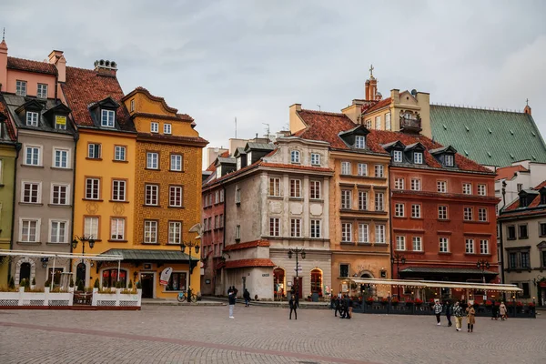 Varşova, Polonya, 13 Ekim 2021: Ortaçağ şehri, Rönesans ve barok tarihi binaların tarihi merkezlerinde güneşli bir gün olan Castle Meydanı 'ndaki renkli binalar