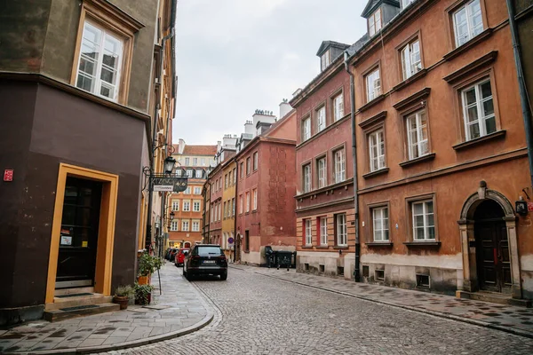 Varşova, Polonya, 13 Ekim 2021: Ortaçağ şehri, Rönesans ve barok tarihi binalarının tarihi merkezlerinde renkli binalar bulunan dar resimli cadde, eski kentte güneşli bir sonbahar günü