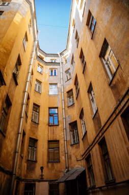 Saint Petersburg, Rusya, 17 Ekim 2021: Merkezde iyi, eski mimari olarak adlandırılan dar bahçeler, aşağıdan bakıldığında, kar getiren sarı evler ve karanlık iç mekanlar arasında gökyüzü görünür.