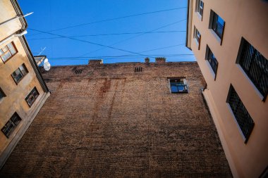 Saint Petersburg, Rusya, 17 Ekim 2021: Merkezde iyi, eski mimari olarak adlandırılan dar bahçeler, aşağıdan bakıldığında, kar getiren sarı evler ve karanlık iç mekanlar arasında gökyüzü görünür.