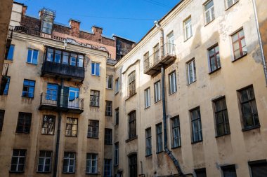 Saint Petersburg, Rusya, 17 Ekim 2021: Merkezde iyi, eski mimari olarak adlandırılan dar bahçeler, aşağıdan bakıldığında, kar getiren sarı evler ve karanlık iç mekanlar arasında gökyüzü görünür.