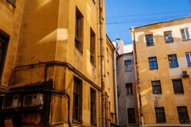 Saint Petersburg, Rusya, 17 Ekim 2021: Merkezde iyi, eski mimari olarak adlandırılan dar bahçeler, aşağıdan bakıldığında, kar getiren sarı evler ve karanlık iç mekanlar arasında gökyüzü görünür.