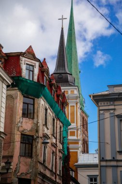 Riga, Letonya, 14 Ekim 2021: St. James Katedrali, Luteryan ve Ortodoks Kilisesi çan kulesiyle, Kuzey Gotik tarzı kırmızı tuğlayla, güneşli bir günde eski şehrin tanınabilir ortaçağ simgesi