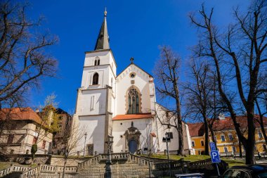 Litomysl, Çek Cumhuriyeti, 17 Nisan 2022: Güneşli yaz gününde kulesi, St. Marquette Kilisesi, taş heykeller ile Kutsal Haç 'ın Gotik Ortaçağ Kilisesi