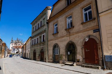 Litomysl, Çek Cumhuriyeti, 17 Nisan 2022: Güneşli yaz gününde ortaçağ renkli gotik ticaret evleri, tarihi rönesans ve barok binaları olan dar resim caddesi