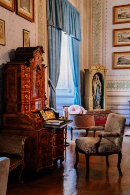 Litomysl, Çek Cumhuriyeti, 17 Nisan 2022: barok klasik mobilya, ahşap yazı masası ve pencere kenarındaki koltuk, fotoğraflar, biblolar ve belgeler ile kale şatosu temsilcisi