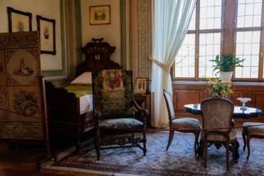 Litomysl, Çek Cumhuriyeti, 17 Nisan 2022: Barok klasik mobilyalarıyla şato temsilcisi, yatak odasında oyulmuş ahşap yatak ve koltuk, aynalı ve dekorasyonlu bayanlar masası