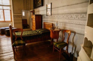 Litomysl, Çek Cumhuriyeti, 17 Nisan 2022: Barok klasik mobilyalarıyla şato temsilcisi, yatak odasında oyulmuş ahşap yatak ve koltuk, aynalı ve dekorasyonlu bayanlar masası
