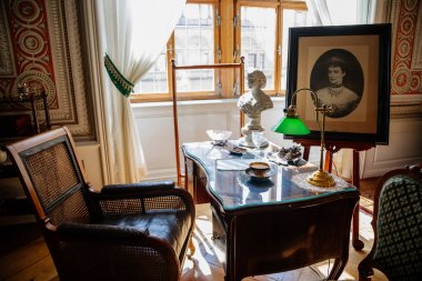 Litomysl, Çek Cumhuriyeti, 17 Nisan 2022: Barok klasik mobilyaları, tahta yazı masası ve pencerelerin yanındaki sandalye, Elizabeth Bavyera 'nın portresi, yeşil tonlu lamba