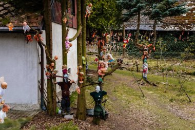 Rvacov near Hlinsko, Czech Republic, 15 April 2022: House of Hanging Dolls, terrible dirty bad plastic dolls hang on trees and on walls, Halloween and horror scary place, Abandoned and lonely toy