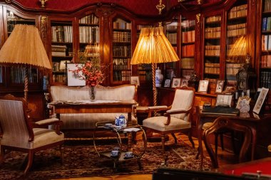 Slatinany, Czech Republic, 17 April 2022:  Castle chateau representative interior with baroque wooden carved furniture, sofa and armchairs, table with porcelain dishes, paintings and photographs