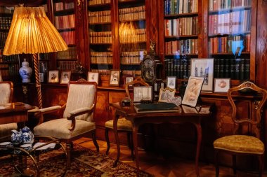 Slatinany, Czech Republic, 17 April 2022:  Castle chateau representative interior with baroque wooden carved furniture, sofa and armchairs, table with porcelain dishes, paintings and photographs