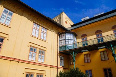 Slatinany, Czech Republic, 17 April 2022: classical chateau or romantic yellow castle surrounded by a garden, ancient aristocratic residence with park in summer sunny day, horse sculpture