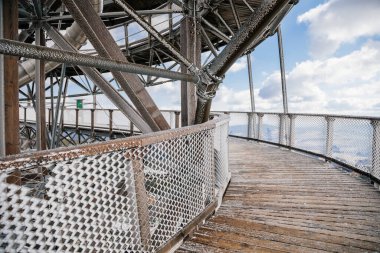 Dolni Morava, Czech Republic, 16 April 2022: Path in the clouds, tourist attraction with spiral platform to observation tower, landscape with forest and sky on mountains, Skywalk with snow