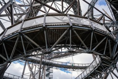 Dolni Morava, Czech Republic, 16 April 2022: Path in the clouds, tourist attraction with spiral platform to observation tower, landscape with forest and sky on mountains, Skywalk with snow