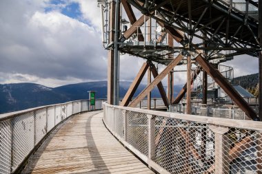 Dolni Morava, Czech Republic, 16 April 2022: Path in the clouds, tourist attraction with spiral platform to observation tower, landscape with forest and sky on mountains, Skywalk with snow
