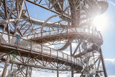 Dolni Morava, Czech Republic, 16 April 2022: Path in the clouds, tourist attraction with spiral platform to observation tower, landscape with forest and sky on mountains, Skywalk with snow