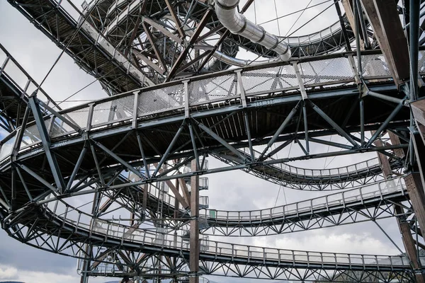 Dolni Morava, Czech Republic, 16 April 2022: Path in the clouds, tourist attraction with spiral platform to observation tower, landscape with forest and sky on mountains, Skywalk with snow