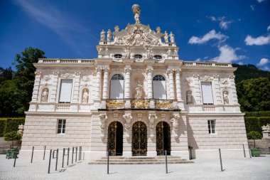 Linderhof Palace, Ettal, Bavaria, Germany, 3 July 2022: Schloss or chateau at rococo style surrounded by gardens and parks, castle built by King Ludwig II based on Versailles, sunny summer day