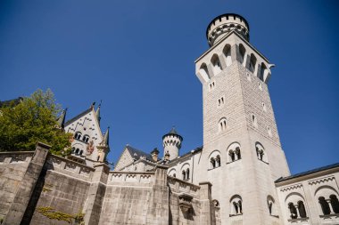 Neuschwanstein, Schwangau, Bavaria, Germany, 3 July 2022: famous tourist attraction in Alps, white castle with towers built by King Ludwig II, fairy tale schloss or chateau at sunny summer day