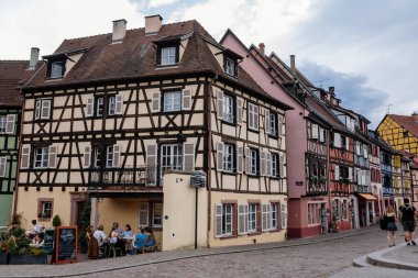 Colmar, Alsace, France, 4 July 2022: town capital of Alsatian wine, narrow picturesque street with medieval colorful houses, Timber framing or post-and-beam construction, romantic city at summer day