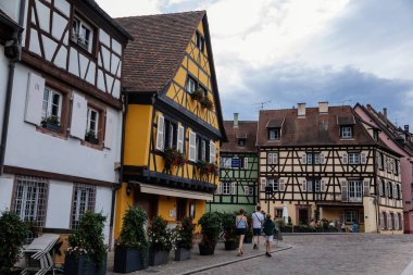 Colmar, Alsace, France, 4 July 2022: town capital of Alsatian wine, narrow picturesque street with medieval colorful houses, Timber framing or post-and-beam construction, romantic city at summer day