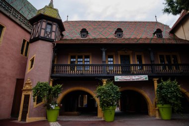 Colmar, Alsace, France, 4 July 2022: town capital of Alsatian wine, narrow picturesque street with medieval colorful houses, Timber framing or post-and-beam construction, small tower