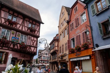 Colmar, Alsace, France, 4 July 2022: town capital of Alsatian wine, narrow picturesque street with medieval colorful houses, Timber framing or post-and-beam construction, romantic city at summer day