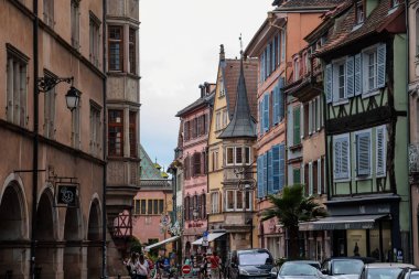 Colmar, Alsace, France, 4 July 2022: town capital of Alsatian wine, narrow picturesque street with medieval colorful houses, Timber framing or post-and-beam construction, romantic city at summer day