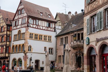 Colmar, Alsace, France, 4 July 2022: town capital of Alsatian wine, narrow picturesque street with medieval colorful houses, Timber framing or post-and-beam construction, romantic city at summer day