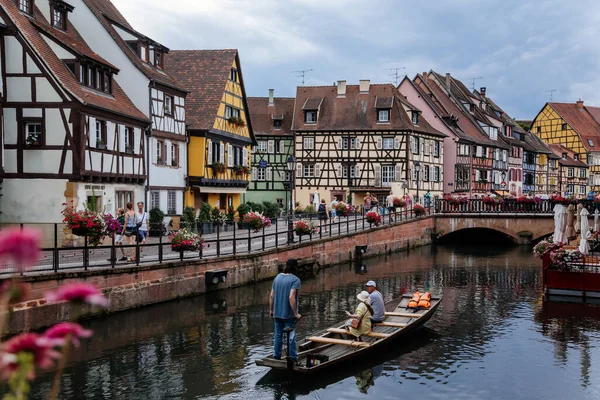 Colmar, Alsace, France, 4 July 2022: town capital of Alsatian wine, narrow picturesque street with medieval colorful houses, Timber framing or post-and-beam construction, Little Venice with channels