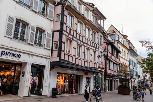 Colmar, Alsace, France, 4 July 2022: town capital of Alsatian wine, narrow picturesque street with medieval colorful houses, Timber framing or post-and-beam construction, people at rue des Clefs