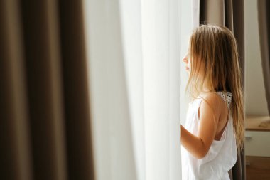 Sabahları pencerenin yanında sarı saçlı sekiz yaşında bir kız çocuğunun portresi.