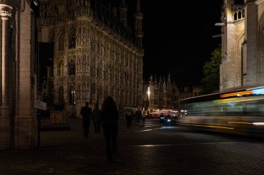 Leuven, Flaman Brabant Bölgesi, Belçika - 09 22 2021: Geceleri Pieter De Somer Meydanı 'nda bir otobüs geçerken