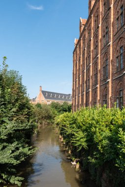 Leuven, Flaman Brabant Bölgesi, Belçika - 09 22 2021: Dyle Nehri 'nde geleneksel Katolik tuğla taş okulu